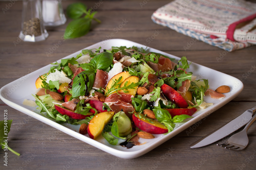 Peach and ham prosciutto salad on white plate. Horizontal photo Peach and ham prosciutto salad on white plate. Horizontal photo