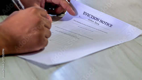 Closeup Asian or African American man signs Eviction Notice