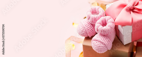 Foto Beautiful composition with pink baby booties and gift box on pink background
