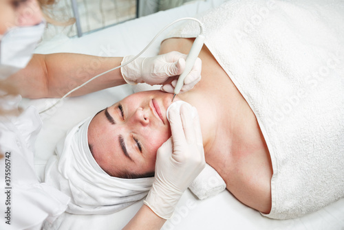 Cosmetologist makes the procedure treatment of couperose Skin cleaning photo