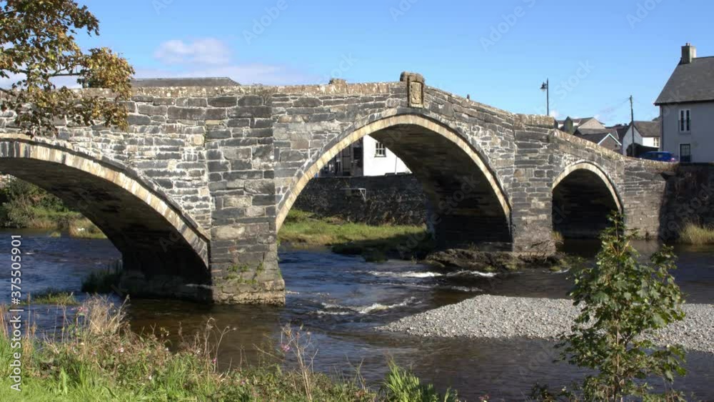 smooth zoom shot of an old bridge in a welsh town with a river flowing beneath