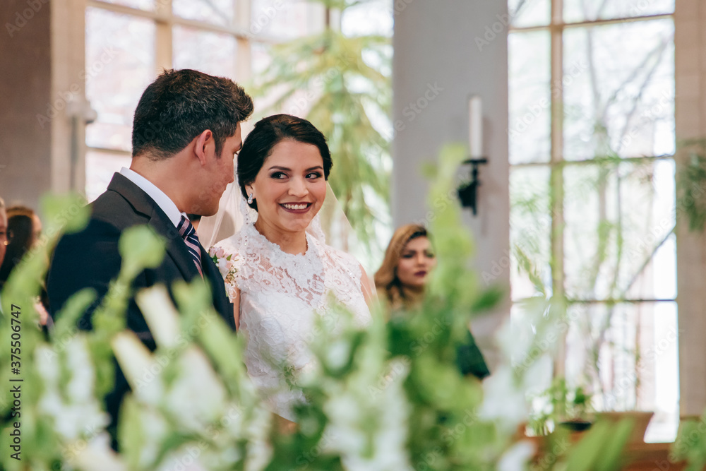 Latino bride and groom looking at each other during the ceremony Latino bride and groom looking at each other during the ceremony