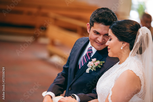 Latino groom says something to the bride during the ceremony