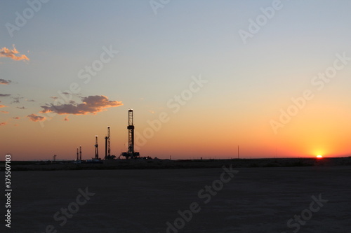 Rare image of the West Texas desert landscape during sunset with 5 drilling rigs in the background.