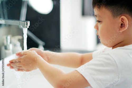 young boy washing his hands