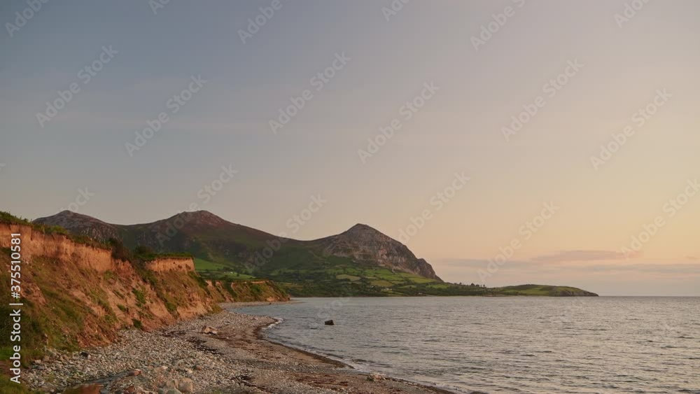 Post card scenery of Wales coastline with large mountain peaks during sunset Post card scenery of Wales coastline with large mountain peaks during sunset