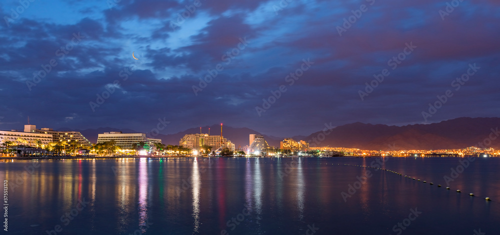 Night panoramic view on the central public beach of Eilat - famous tourist resort and recreational city in Israel

