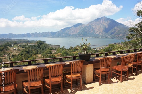 Batur Lake view from balcony with row of wooden chairs © Jason
