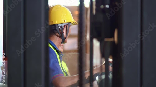 Asian forklift driver in uniform and helmet talk with female manager in warehouse argo