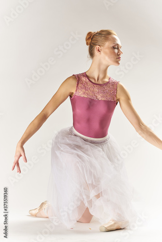 woman ballerina in pointe shoes and in a tutu on a light background poses posing legs dance model