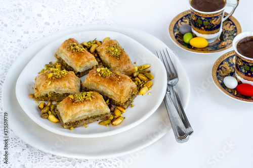 Traditional Turkish Pastry Dessert Pistachio Baklava on white with Turkish Coffee,cutlery set 