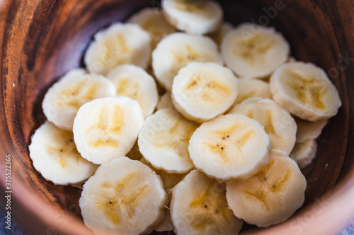 simple food ingredients, sliced banana in wooden bowl as healthy snack