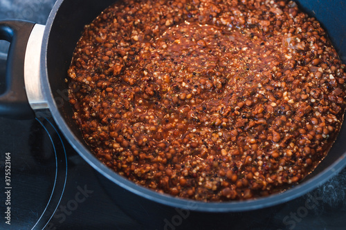 plant-based food, vegan lentil and textured vegetable protein ragu with quinoa in pot