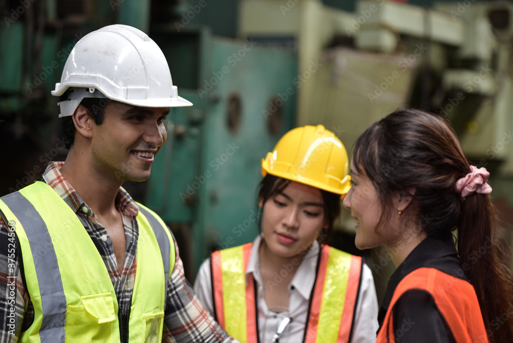 Group of technician man and industrial women worker with hard hat or helmet and vest jacket working electronic machinery and mechanical engineering in Factory of manufacturing place Group of technician man and industrial women worker with hard hat or helmet and vest jacket working electronic machinery and mechanical engineering in Factory of manufacturing place