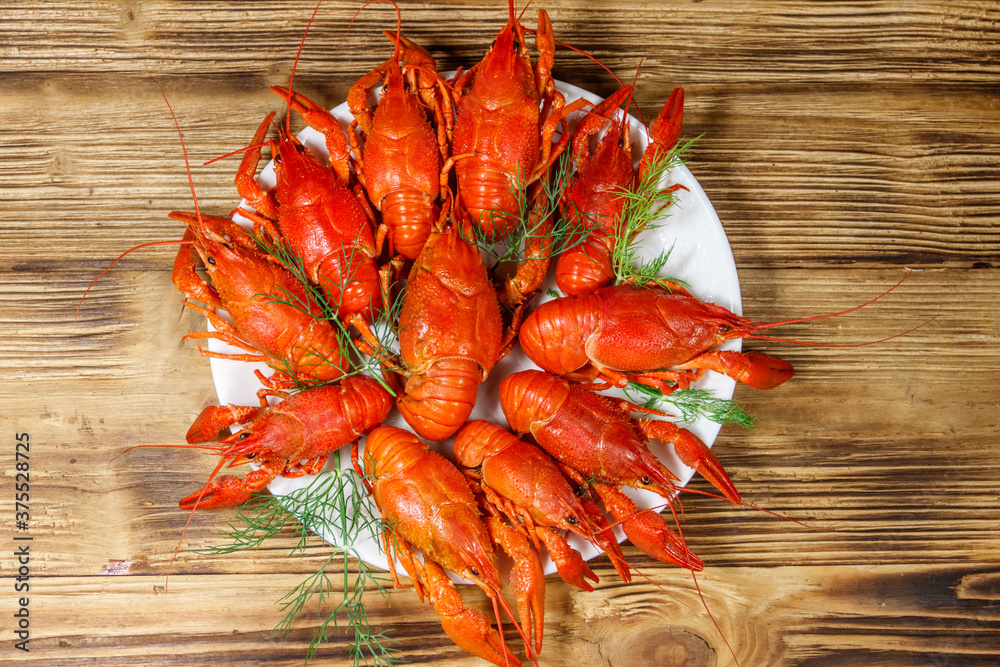 Boiled crayfish in plate on wooden table. Top view Boiled crayfish in plate on wooden table. Top view