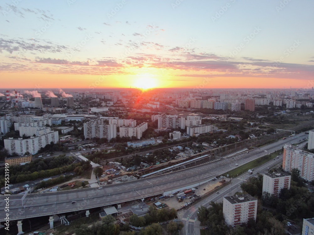 Aerial view panoramic landscape of Moscow city at sunrise. Multi-level intersection on an expressway in the city in the rays of the golden sun. Drone shot
