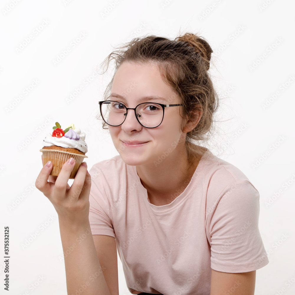 Cute beautiful teen girl with glasses eating cream cake on white background Cute beautiful teen girl with glasses eating cream cake on white background