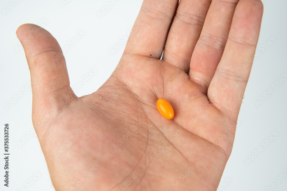 hand holding a pill hand holding a pill
