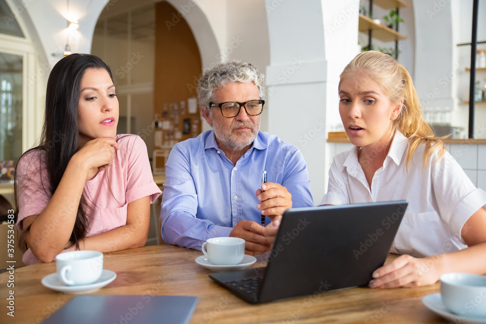 Confident female manager showing presentation on laptop to young woman and mature man, speaking and explaining details. Consulting or communication concept Confident female manager showing presentation on laptop to young woman and mature man, speaking and explaining details. Consulting or communication concept