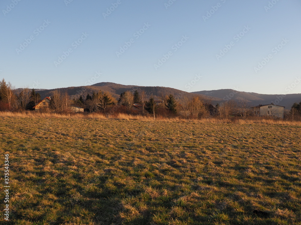 Picturesque Silesian Beskid Mountains range seen from sport airfield in european Bielsko-Biala city in Poland, clear blue sky in 2020 warm sunny spring day on April at sun set.