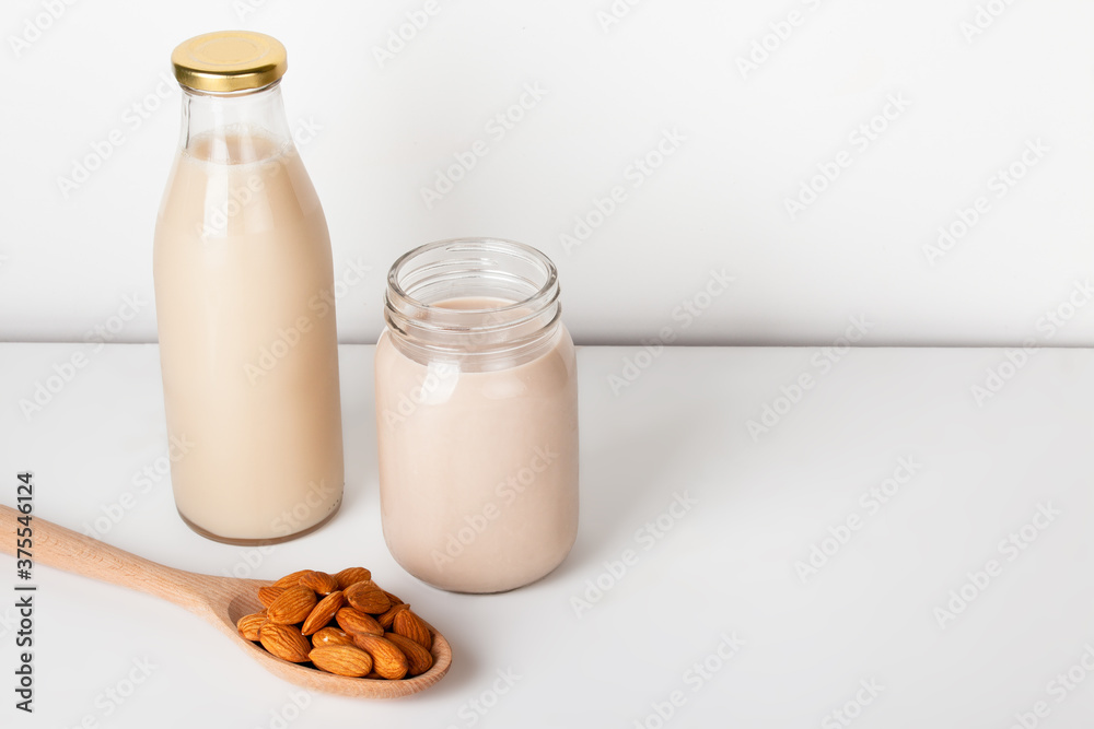 Almond milk in glass with almonds on table with copy space Almond milk in glass with almonds on table with copy space