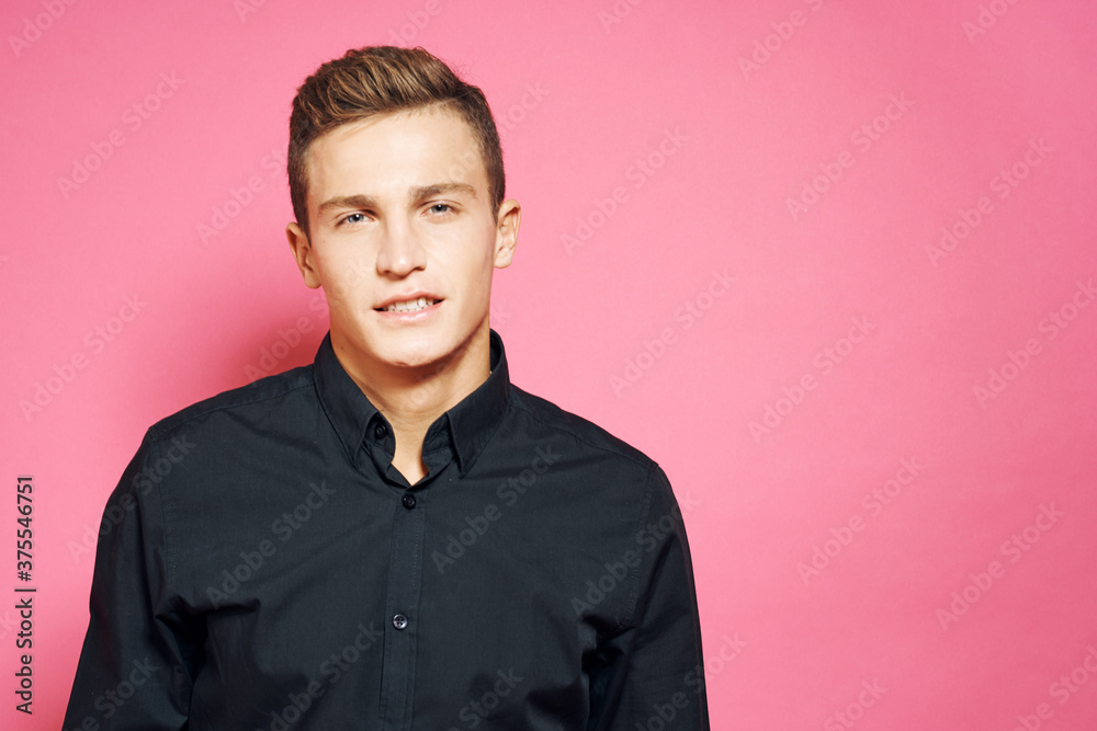 Man in black shirt gestures with hands lifestyle pink isolated background Man in black shirt gestures with hands lifestyle pink isolated background