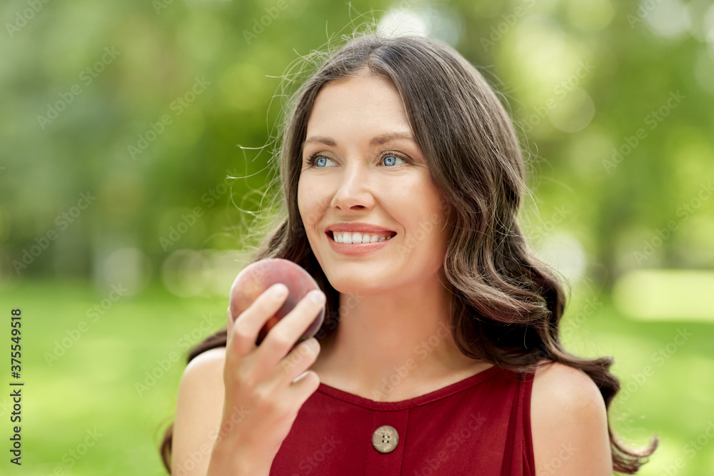 healthy eating and people concept - portrait of happy woman with peach at summer park healthy eating and people concept - portrait of happy woman with peach at summer park