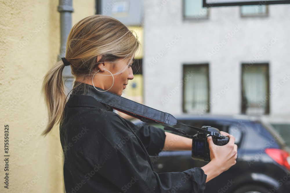 Fototapeta premium Young blond woman taking a photo outside