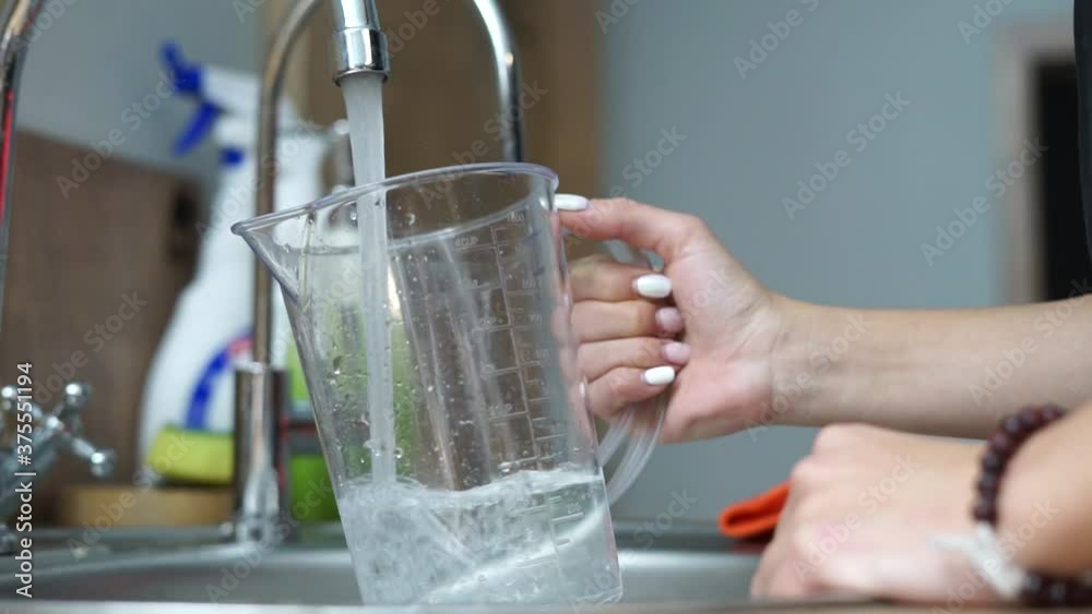A set of water in a measuring cup from faucet. A set of water in a measuring cup from faucet.