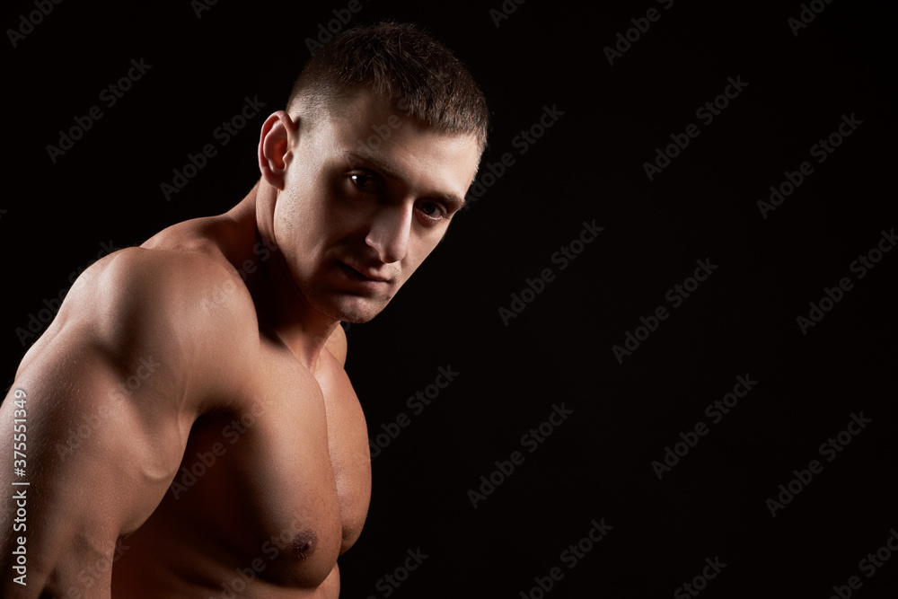 Portrait of muscular bodybuilder on black background.Studio shot