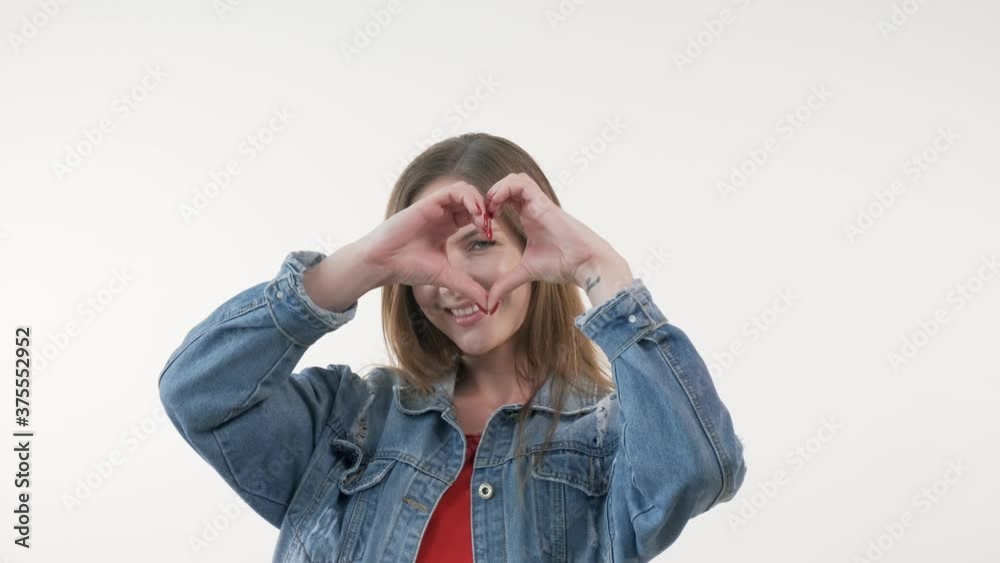 A beautiful woman looks at the camera and confesses her love, sends an air kiss. White background.