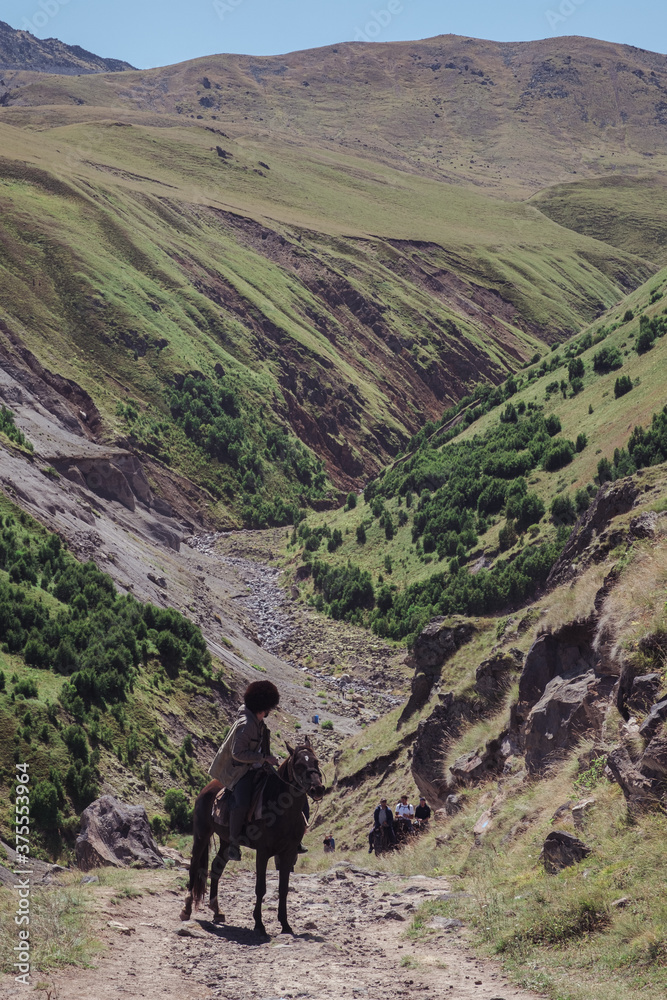 Mountain guide, mountain landscape and horse rider, aboriginal