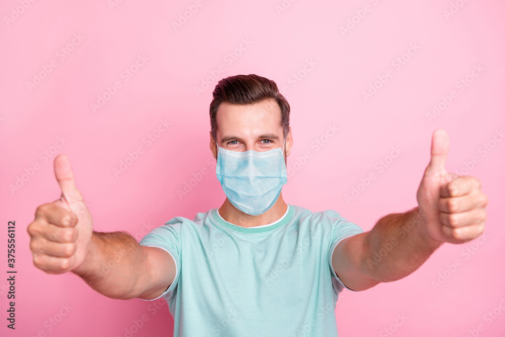 Close-up portrait of his he nice attractive content man showing thumbup wearing safety gauze mask influenza contamination preventive measures isolated over pink pastel color background Close-up portrait of his he nice attractive content man showing thumbup wearing safety gauze mask influenza contamination preventive measures isolated over pink pastel color background