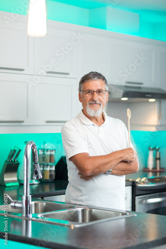 Senior man standing in his renovated  modern kitchen 