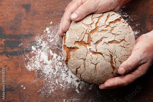 Baker holding fresh baked homemade bread