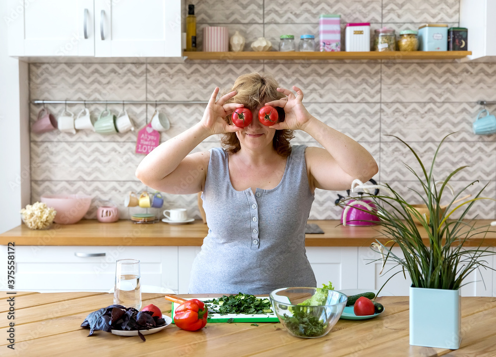 A young woman prepares a vegetable salad in her kitchen. A young woman prepares a vegetable salad in her kitchen.