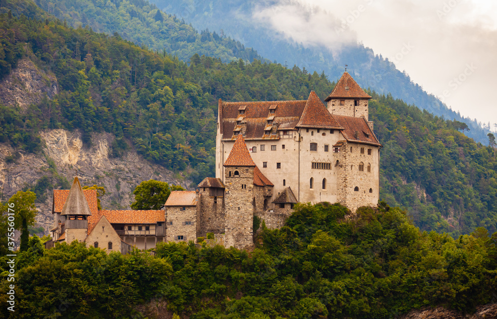 Scenic view of medieval Gutenberg Castle on hilltop between greenery on cloudy summer day, Balzers, Liechtenstein