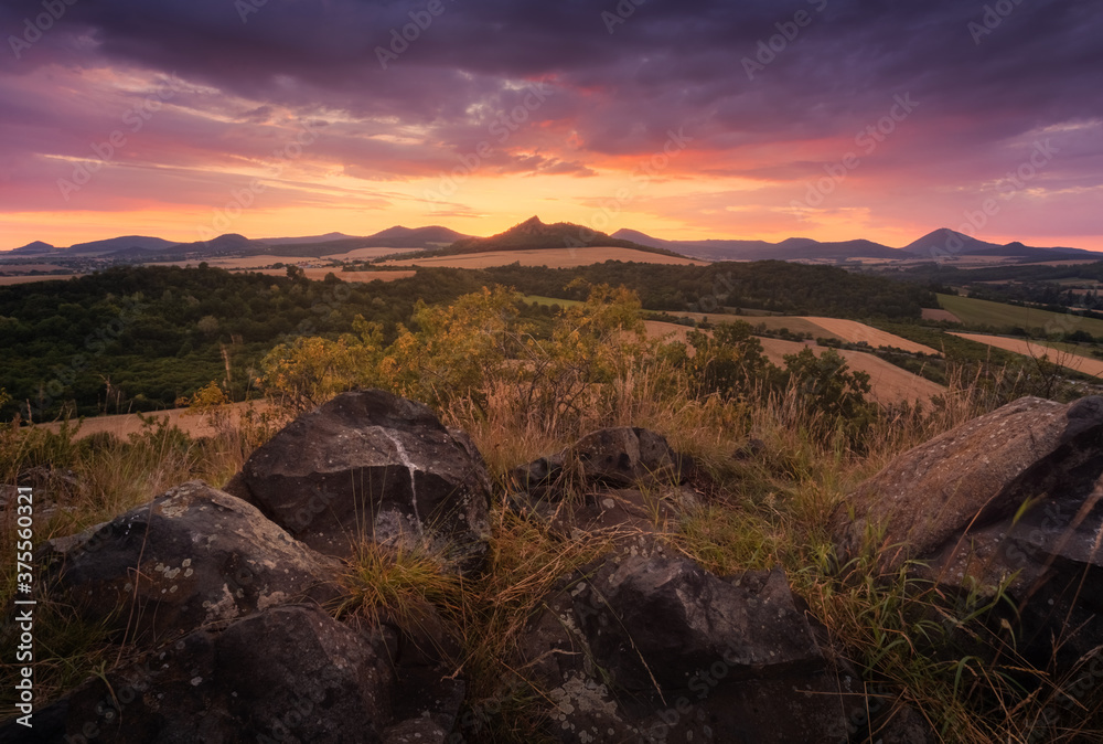 Beautiful colorful sunset over Czech Central Mountains (ceske stredohori) from small village Trebenice, Czech Republic