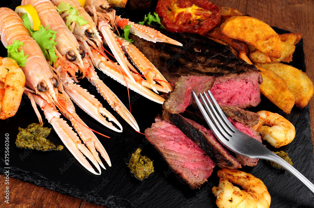 Φωτογραφία Surf and turf meal with sirloin steak, langoustine and tiger prawns