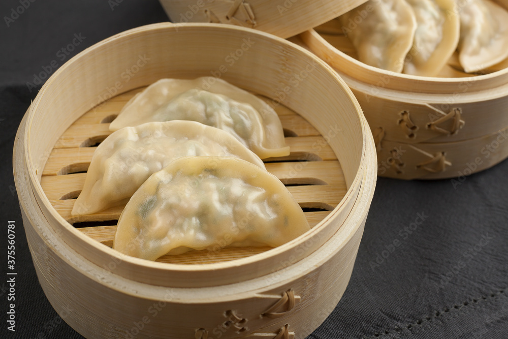 Delicious Korean mandu or gyozas served on a wood steamer cooked.