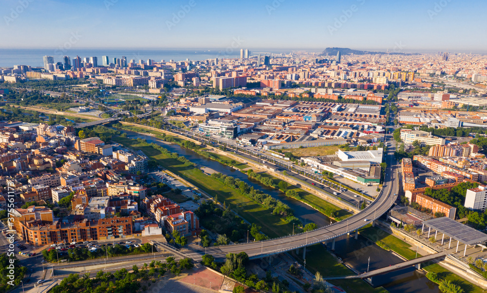 Aerial panoramic view of Sant Adria de Besos and Barcelona on Besos river with Mediterranean sea in background on sunny day, Spain