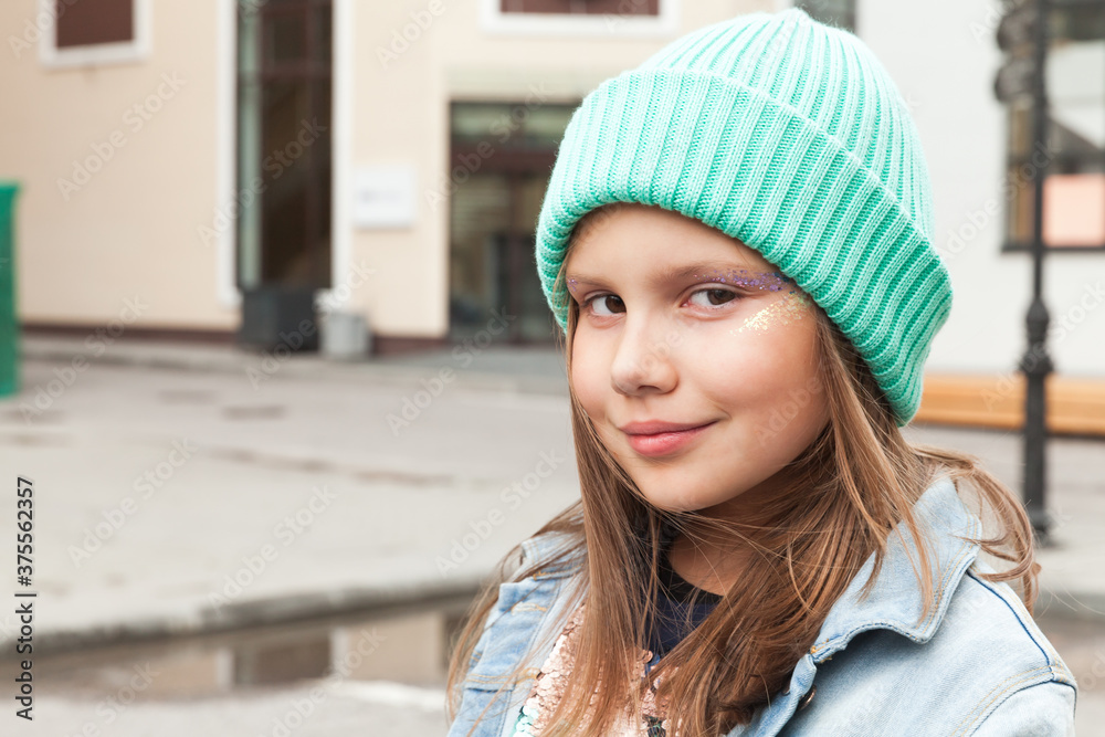 Little girl in green hat with glitter makeup Little girl in green hat with glitter makeup