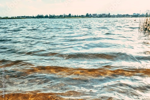 Waves of the city lake with dirty yellow water. Bathing is forbidden.