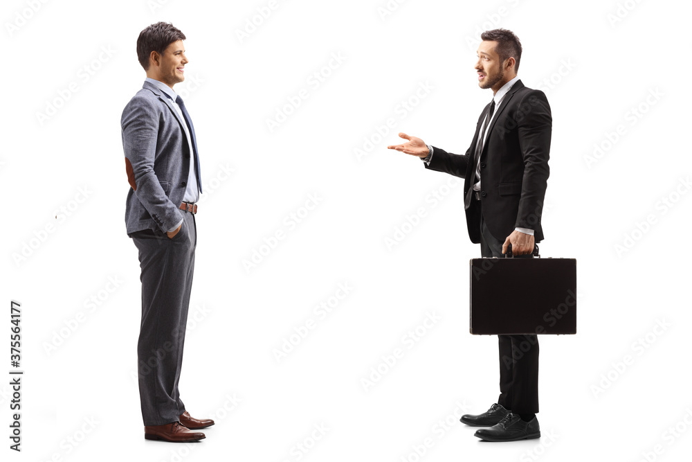 Full length profile shot of a businessman in a suit with a briefcase talking to a man Full length profile shot of a businessman in a suit with a briefcase talking to a man