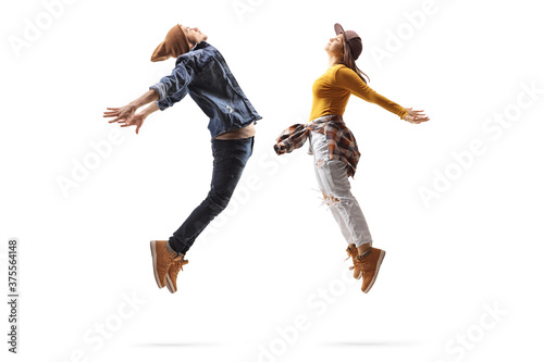 Fototapeta Naklejka Na Ścianę i Meble -  Full length profile shot of a male and female dancers jumping