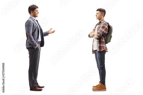 Full length profile shot of a man in a suit and a male student having a conversation
