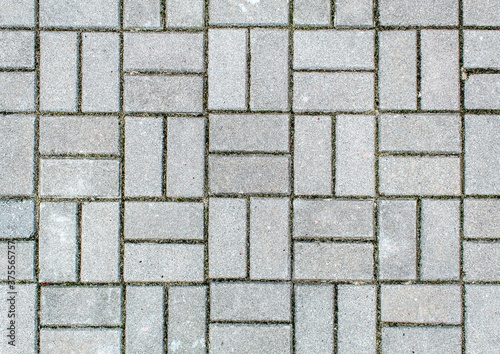 road paved with sidewalk tiles. texture of light gray bricks.
