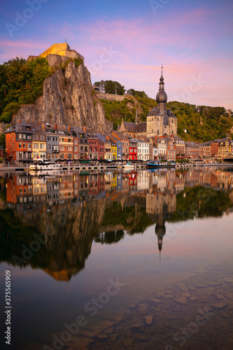 Obraz na płótnie Dinant, Belgium. Cityscape image of beautiful historical city of Dinant with the reflection of the city in the Meuse River at summer sunset. w salonie