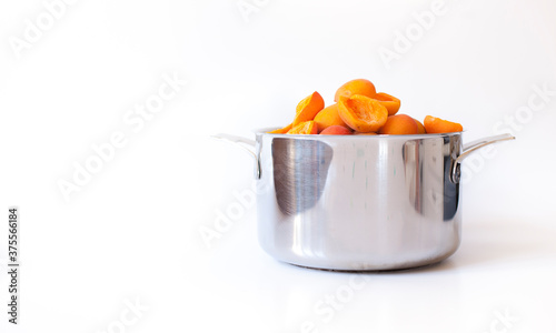 
Fresh apricots in a pot for homemade apricot jam against a white background.
Frische Marillen im Topf für selbstgemachte Apricosen Konfitüre vor weißem Hintergrund.  photo