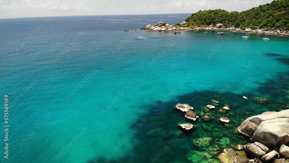 Tourist boats in tropical bay. Drone view of tourist boats with divers and snorkelers floating on calm sea water in Hin Wong Bay of tropical volcanic Koh Tao Island in Thailand.
